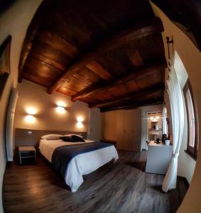 a bedroom with a large bed with a wooden ceiling at Delzanno in Varallo