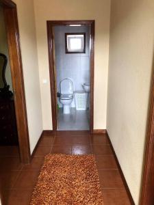 a bathroom with a toilet and a door with a rug at Douro vineyards and Mountains in Urgueira