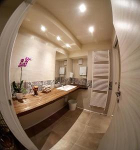 La salle de bains est pourvue d'un lavabo et d'un grand miroir. dans l'établissement Delzanno, à Varallo