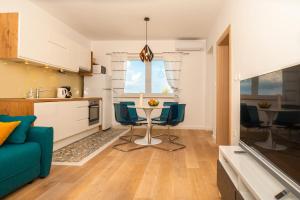 a kitchen and living room with a table and chairs at Apartments Mistral in Bol