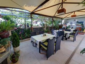 an outdoor patio with tables and chairs and plants at Family Hotel Gogov in Sinemorets