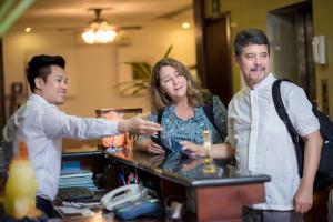 a group of three people standing around a counter at Hanoi 3B Premier Hotel in Hanoi