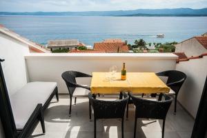 a table and chairs on a balcony with a view of the ocean at House Koloc in Bol