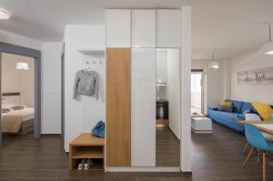 a living room with a large glass partition and a blue couch at Apartmani Kos in Supetar