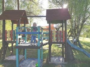 a little girl is standing on a playground at Domki Victoria in Sasino