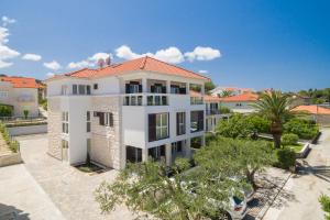 a large white building with a red roof at Apartmani Kos in Supetar