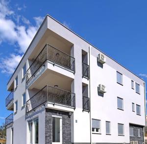 een wit gebouw met balkons aan de zijkant bij Oleandra Apartments in Drage