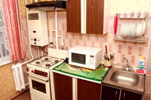 a small kitchen with a microwave and a sink at Prime Home 4 in Chernihiv