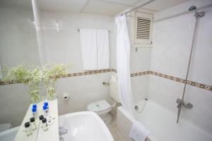
a bathroom with a tub, toilet, sink and shower at Gandia Playa in Gandía
