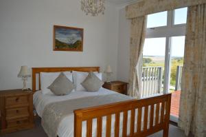 a bedroom with a bed and a large window at Strathview Lodge in Dornoch