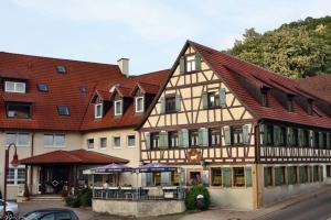 a large building with red roof at Akzent Hotel Goldener Ochsen in Cröffelbach