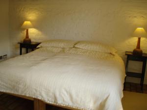 Un dormitorio con una cama blanca con dos lámparas. en Top Parts Bed & Breakfast, en Abbotsbury