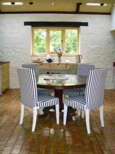 a dining room with a wooden table and two chairs at Top Parts Bed & Breakfast in Abbotsbury