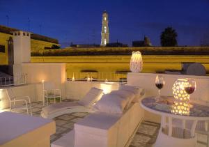 een balkon met een tafel en stoelen en een klokkentoren bij B&B Corte dell' Idume in Lecce