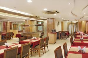 um restaurante com mesas e cadeiras com toalhas de mesa vermelhas em Southern Regency em Nova Deli