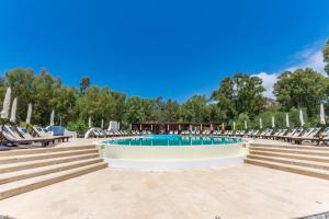 una piscina con tumbonas y una piscina en Vulcano Blu Residence en Vulcano