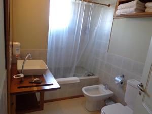 a bathroom with a sink and a toilet and a shower at Del Nomade Hosteria Ecologica in Puerto Pirámides