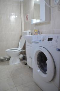 a bathroom with a washing machine and a toilet at Alexys Residence 9 in Iaşi