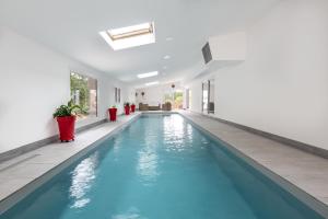 an indoor swimming pool with blue water in a house at Gite Manttu in Urrugne