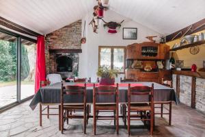 a dining room with a table and chairs and a fireplace at Gite Manttu in Urrugne