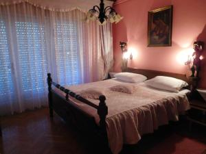 a bedroom with a large bed and two windows at Apartments Edi - Captain's House in Mošćenička Draga