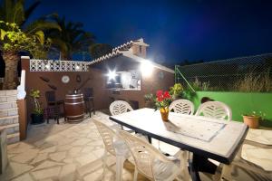 einen Tisch und Stühle auf einer Terrasse in der Nacht in der Unterkunft Casa Malonda in Teulada