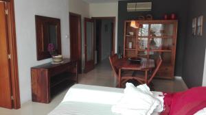 a bedroom with a bed and a table and a dining room at Playa y Sol in Cubelles