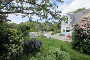 a white house with a yard with flowers at L'Agapanthe in Pléneuf-Val-André