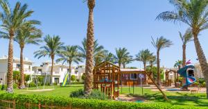 park z palmami i placem zabaw w obiekcie Island View Resort w Szarm el-Szejk