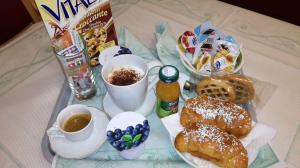 un tavolo con colazione a base di prodotti da forno, caffè e bevande di Albergo Rio a Canistro