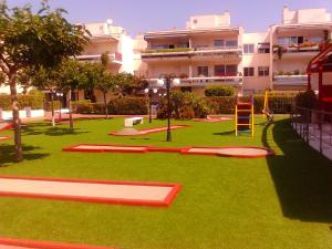a playground in front of a large building at Playa y Sol in Cubelles