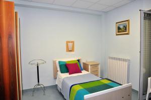 een kleine slaapkamer met een bed met kleurrijke kussens bij Albergo Rio in Canistro