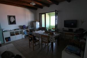 a living room with a table with chairs and a television at S'Archittu Bed&Breakfast in S'archittu Cuglieri