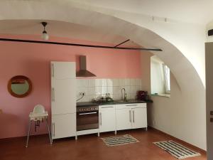 una cocina con armarios blancos y un arco en Artemis Farm Apartments, en Bad Blumau