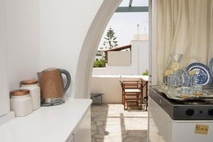 a kitchen with an archway and a table with dishes at Eirinaki House in Patmos