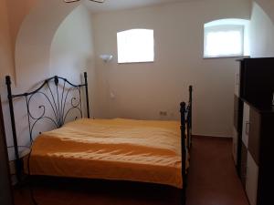 1 dormitorio con 1 cama y 2 ventanas en Artemis Farm Apartments, en Bad Blumau