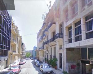 eine Stadtstraße mit Autos neben Gebäuden in der Unterkunft Plaka Vintage in Athen