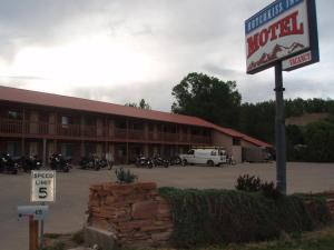 a motel sign in front of a building with motorcycles at Hotchkiss Inn Motel in Hotchkiss