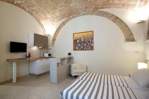 een kamer met een bed, een bureau en een keuken bij Victoria Royal Apartments in Termoli