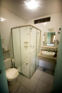 uma casa de banho com um chuveiro, um WC e um lavatório. em Hotel Guanxi em Monte Verde
