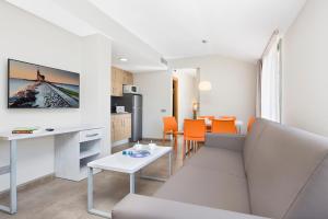 a living room filled with furniture and a couch at Aparthotel Odissea Park in Santa Susanna