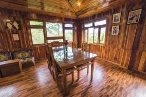una sala da pranzo in legno con tavolo in legno e finestre di Yangsum Heritage Farm a Rinchingpong