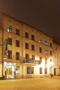 duży budynek z znakiem na nim w nocy w obiekcie Hotel Pod Orłem w Toruniu