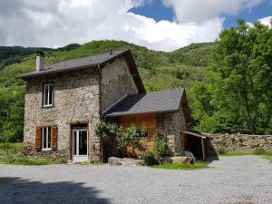 an old stone house in front of a mountain at Gite la Fargue de Cabre in Vicdessos