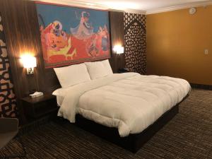 a bedroom with a large bed with a painting on the wall at The Lincoln Hotel Philadelphia in Trevose