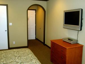 ein Schlafzimmer mit einem Bett und einem TV auf einer Kommode in der Unterkunft Deluxe Inn Redwood City in Redwood City