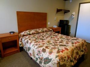 a bedroom with a bed with a floral bedspread at Deluxe Inn Redwood City in Redwood City