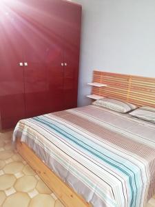 una camera con letto e testiera in legno di La Praia 12 a Favignana