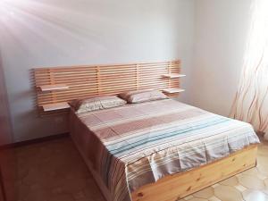 un letto in una camera con testiera in legno di La Praia 12 a Favignana