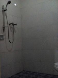 a bathroom with a shower and a toilet at Parama Hotel in Wonosobo